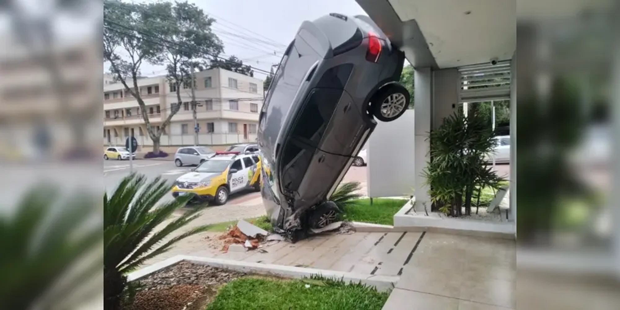 Carro fica trepado na fachada de prédio após acidente em Curitiba