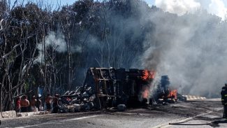 Motorista morre carbonizado após caminhão carregado com botijões de gás tombar na BR-277; Indígenas saqueiam a carga
