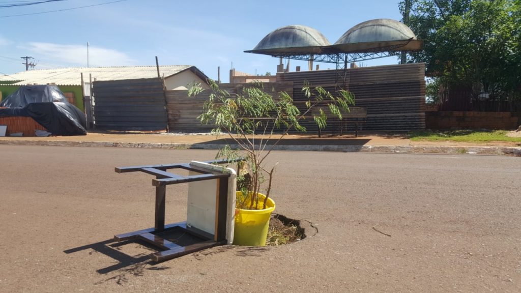 Cadeira e balde com planta são usados para sinalizar cratera que se formou em rua no Bairro Cataratas
