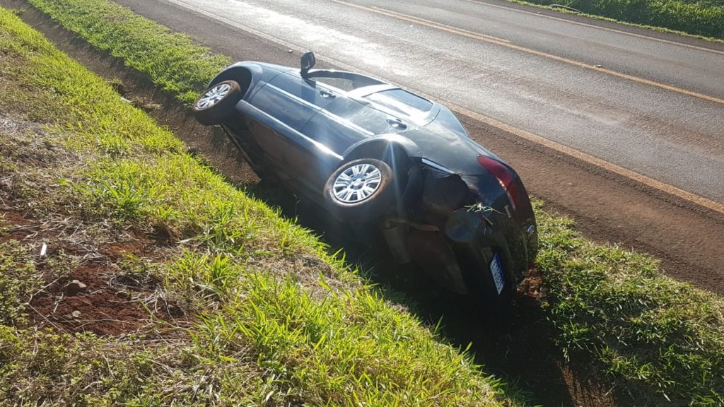 Carro sai da pista e fica tombado em canaleta na PR-486 em Cascavel