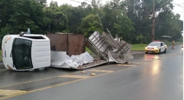 Motorista perde o controle de caminhão, bate contra poste e tomba