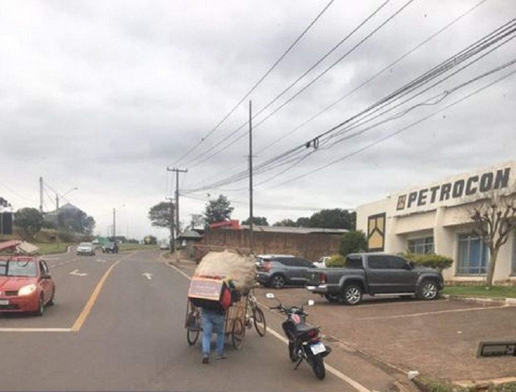 Homem desce da moto para ajudar coletor de recicláveis no viaduto do Bairro XIV de Novembro