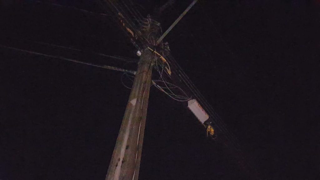 Fios de energia soltos após temporal são amarrados em portão de residência para evitar acidentes