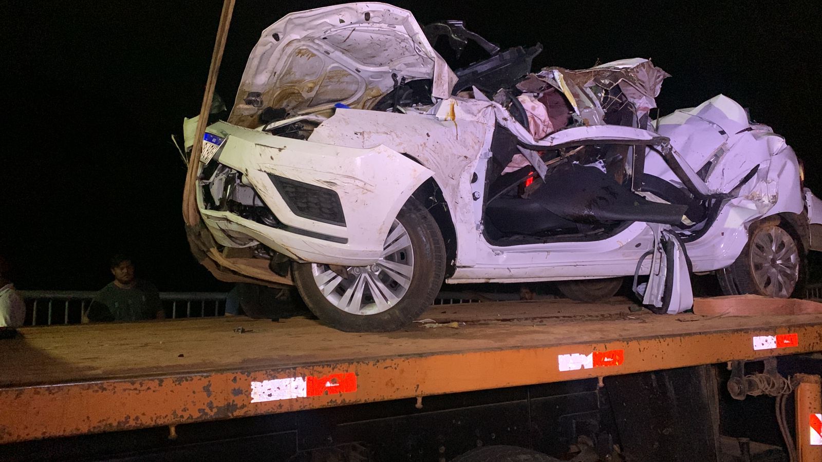 Com auxílio de guindaste, carro que caiu em rio é removido; Veículo ficou completamente destruído