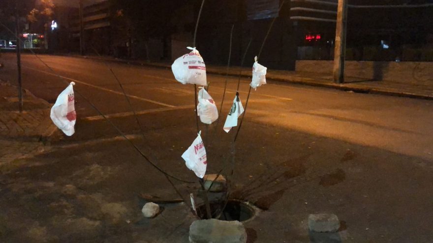 Populares sinalizam buraco na Rua Paraná com galhos e sacolas