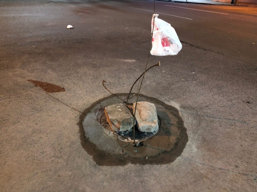 Buraco na Rua Paraná é arrumado após populares sinalizarem com galhos e sacolas