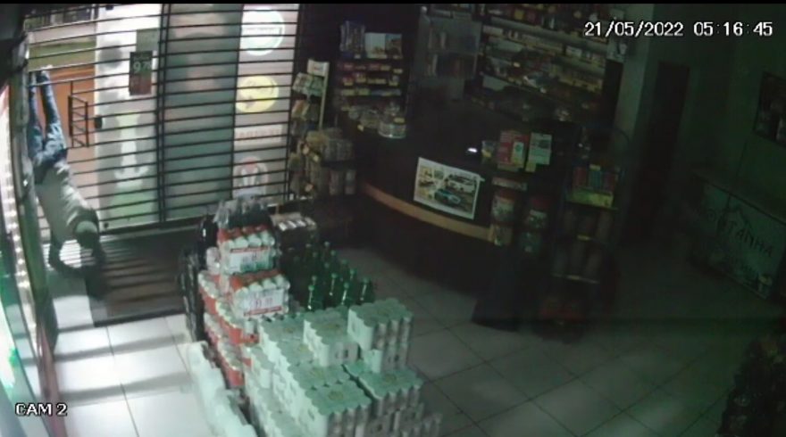 Vídeo mostra ladrão se espremendo em grade de empresa durante arrombamento e furto