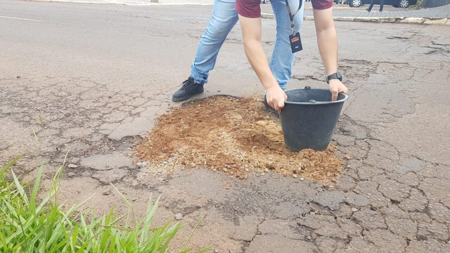 Populares cobrem buraco com terra e serragem na Av. Rocha Pombo