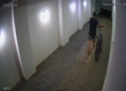 Imagens flagram ladrão furtando bicicleta após arrombar portão da garagem de prédio no centro