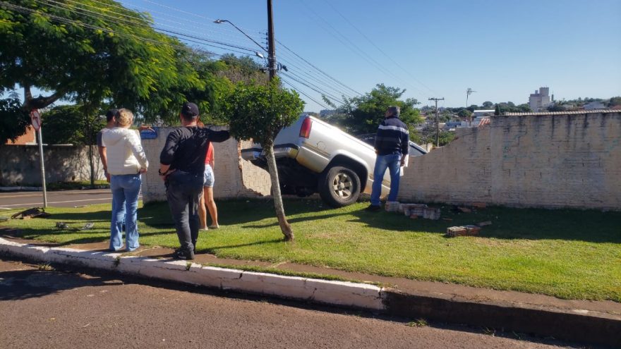 Caminhonete bate contra muro e fica pendurada em desnível de lote