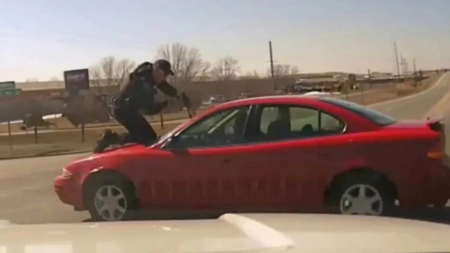 Policial se equilibra em cima de carro durante perseguição intensa