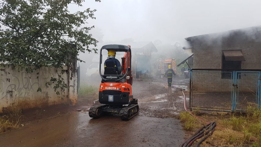 Mini escavadeira é encaminhada a local de incêndio para auxiliar na retirada de material combustível