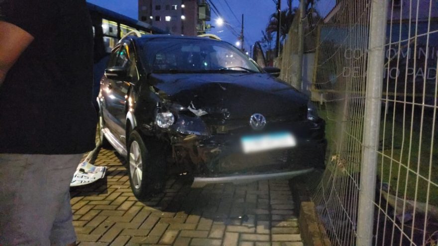 Palio para no semáforo, Crossfox atinge a traseira, derruba placa e acerta grade