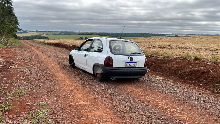 Corsa com alerta de furto é encontrado depenado em estrada rural