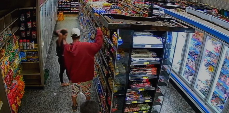 Câmera mostra momento em que jovem coloca garrafa de bebida dentro de calça em supermercado