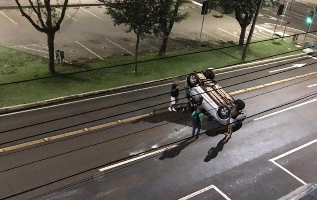 Condutora atinge carro estacionado e capota o Fox na Avenida Brasil Condutora atinge carro estacionado e capota o Fox na Avenida Brasil