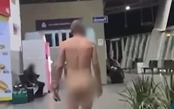 Peladão, homem caminha tranquilamente pela rodoviária