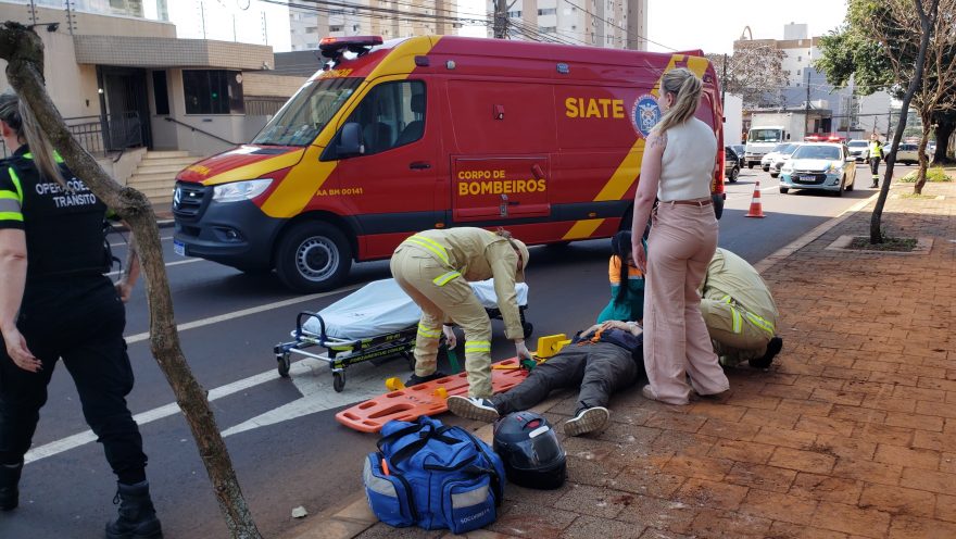 Motociclista joga a moto para o lado para evitar colisão traseira em semáforo, mas sofre a queda