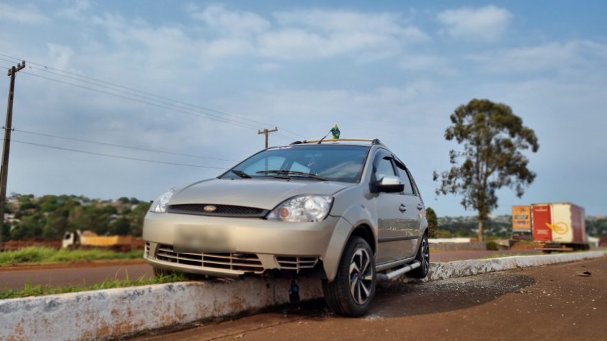 Fiesta fica suspenso em meio-fio na marginal da BR-277 em Cascavel