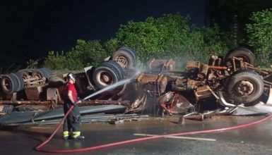 Imagem referente a Carreta tomba e motorista de 74 anos fica preso às ferragens