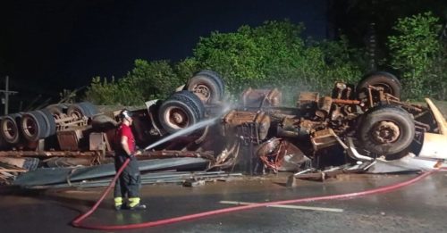 Imagem referente a Carreta tomba e motorista de 74 anos fica preso às ferragens