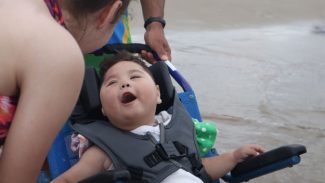 Praia Acessível garante banho de mar de aniversário a criança; 406 pessoas usaram o programa