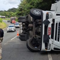 Imagem referente a Caminhão carregado com retalhos de tecidos tomba e interdita faixa da BR-376