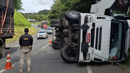 Imagem referente a Caminhão carregado com retalhos de tecidos tomba e interdita faixa da BR-376