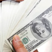 Imagem referente a Dólar encosta em R$ 6 após Trump impor taxa de 104% à China