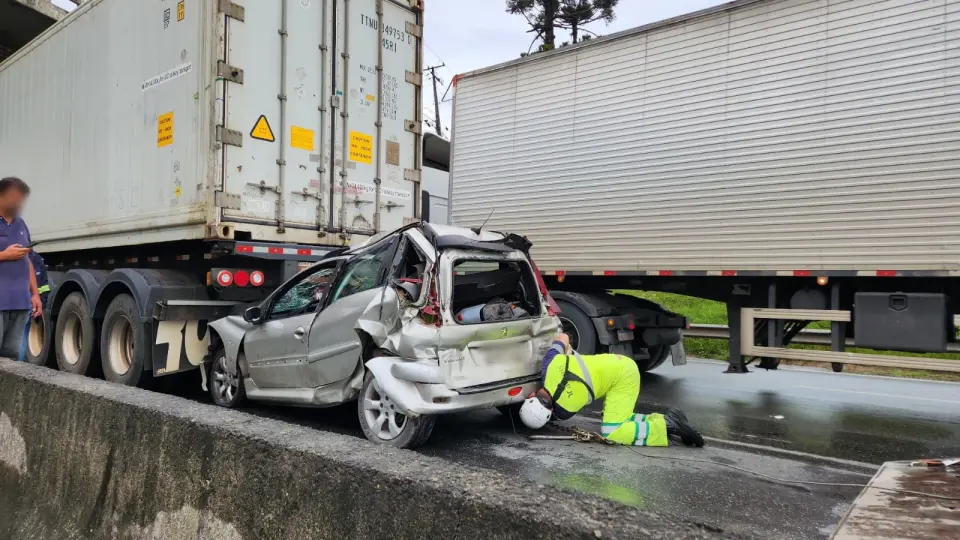 Motorista sobrevive após carro ser prensado entre duas carretas Motorista sobrevive após carro ser prensado entre duas carretas