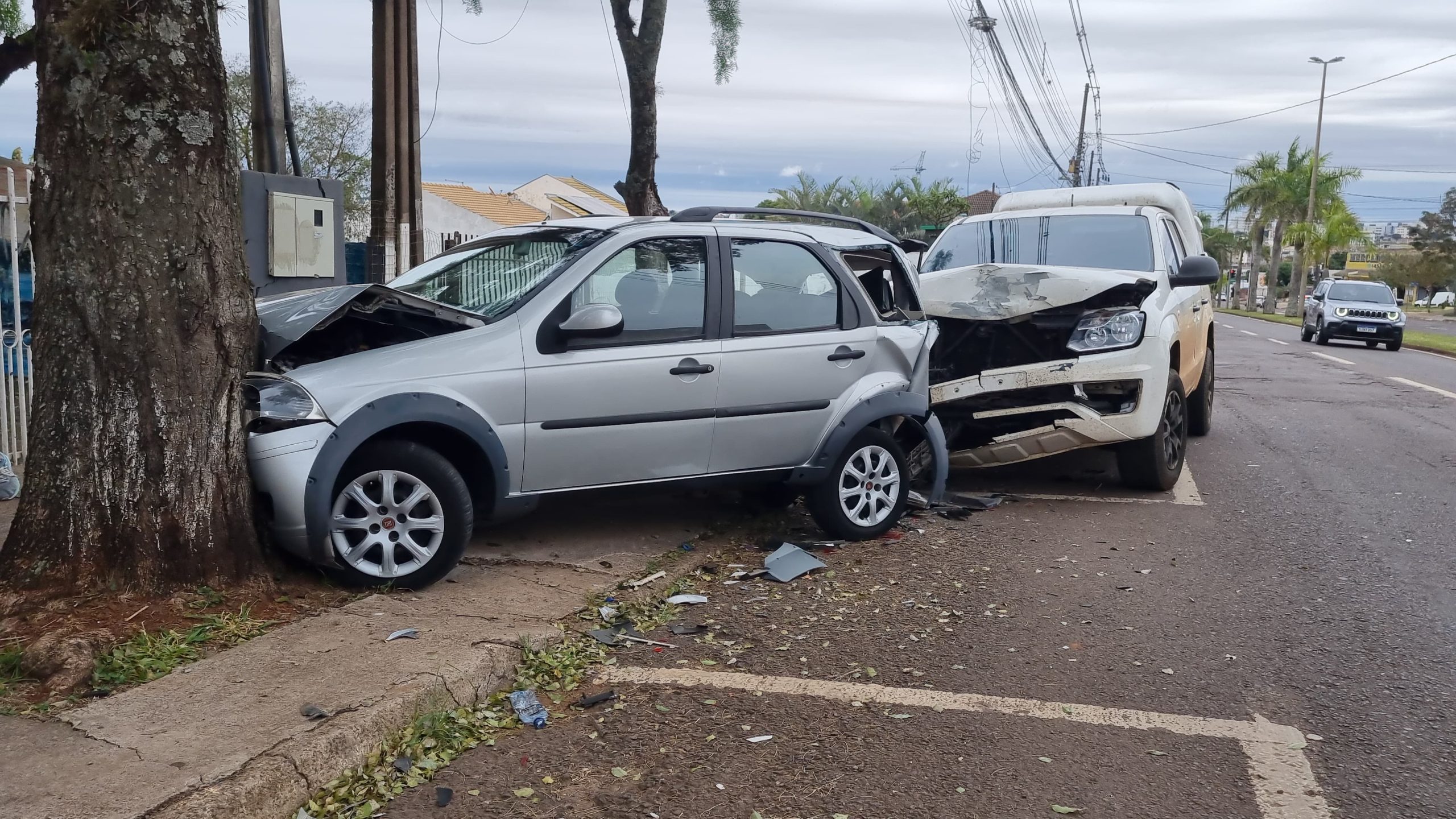 Palio fica prensado entre árvore e Amarok em acidente na Avenida Brasil