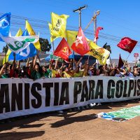 Imagem referente a Manifestantes queimam bandeira dos EUA e boneco de Trump em embaixada