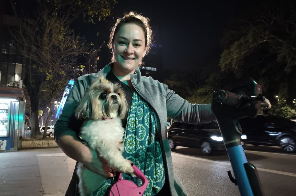 Mulher faz passeio de sling com seu cachorro em patinete alugado da prefeitura