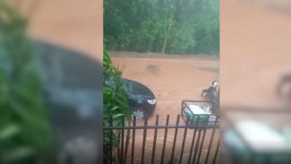 Chuva forte vira pesadelo: Rua alagada e morador tenta desentupir bueiro