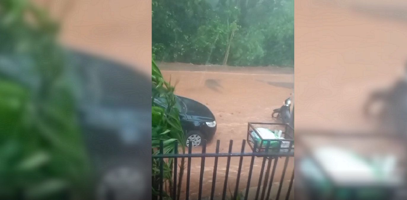 Chuva forte vira pesadelo: Rua alagada e morador tenta desentupir bueiro