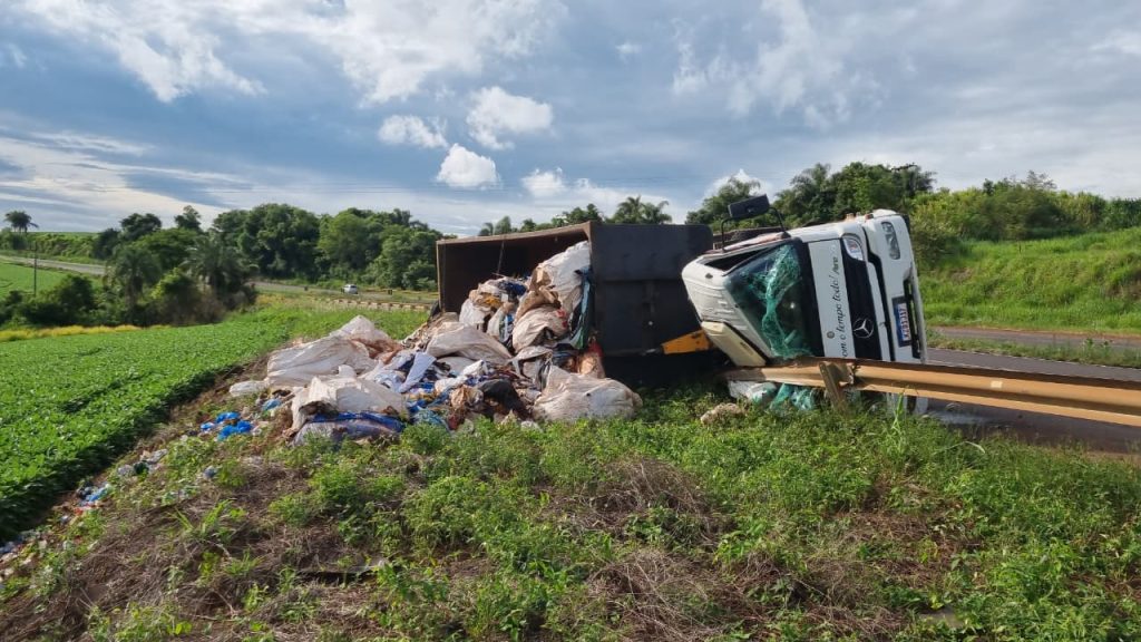 Caminhão carregado com recicláveis tomba sobre guard-rail e condutor fica ferido na BR-163 em Cascavel