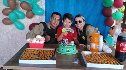PM faz surpresa em aniversário e criança entrega o primeiro pedaço do bolo para a equipe PM faz surpresa em aniversário e criança entrega o primeiro pedaço do bolo para a equipe