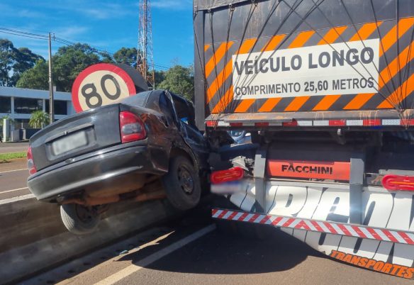 Corsa fica suspenso entre caminhão e mureta após acidente na BR-277, em Cascavel