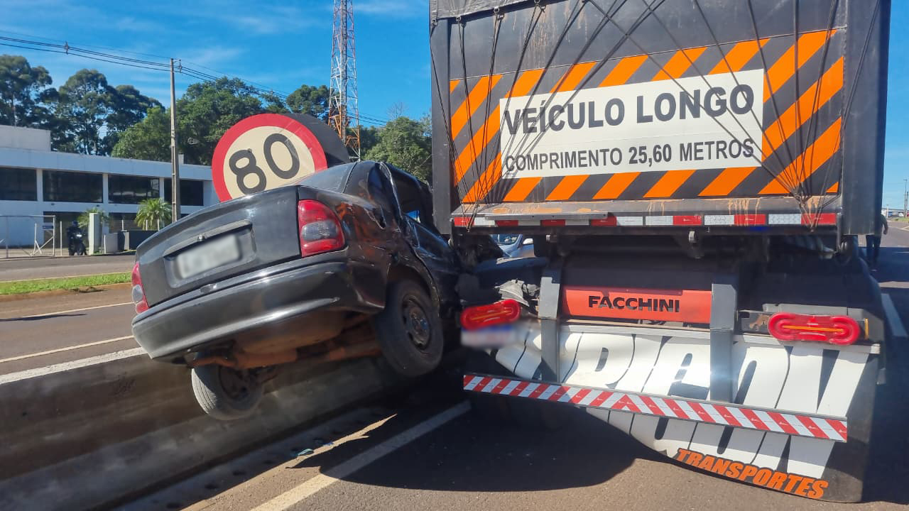 Corsa fica suspenso entre caminhão e mureta após acidente na BR-277, em Cascavel