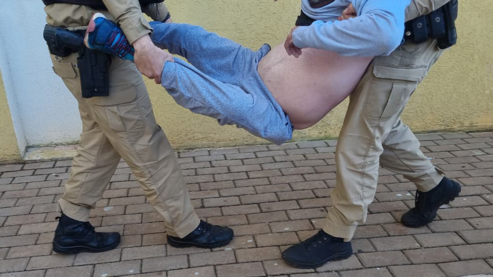 “Caindo de bêbado”, motorista é carregado por policiais na delegacia de Cascavel