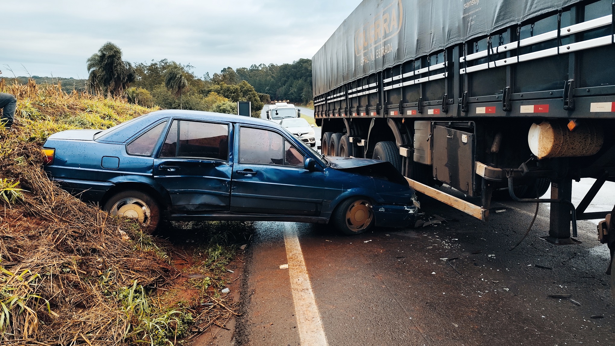 Santana roda na BR-163, é atingido por carreta e fica prensado em barranco em Cascavel