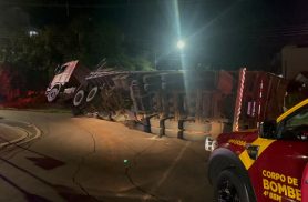 Caminhão tomba após carga pender e provoca vazamento de diesel na Rua Áustria