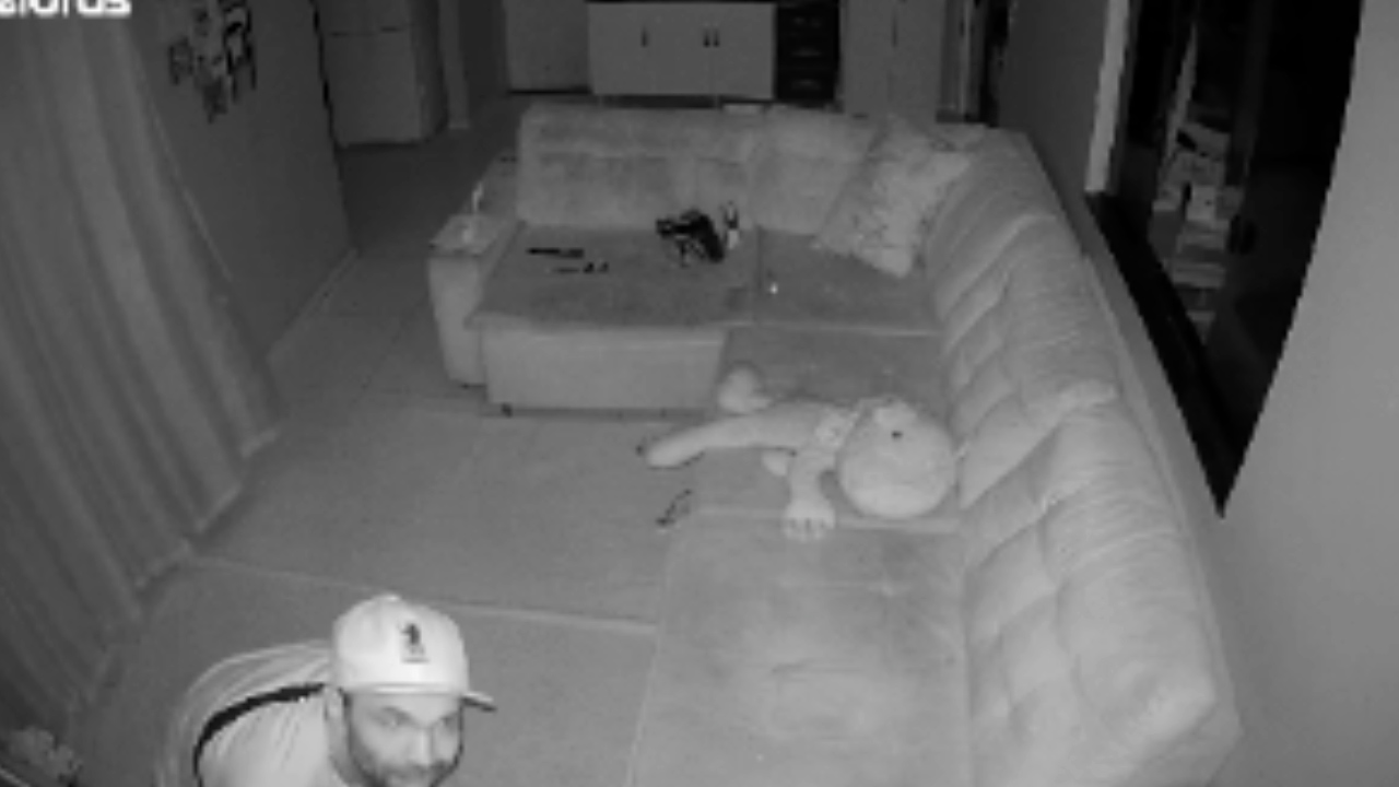 Imagem flagra homem invadindo casa e danificando câmera para realizar furto de TV e celular