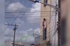 Menina cai de janela, fica pendurada em fios elétricos e é salva por policial