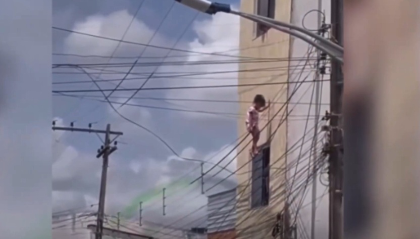 Menina cai de janela, fica pendurada em fios elétricos e é salva por policial